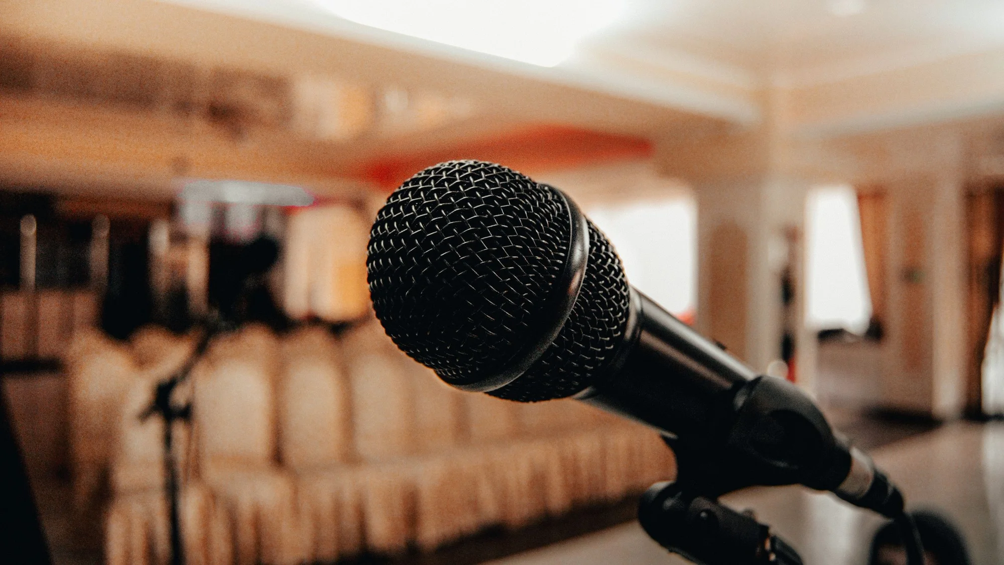 A microphone on a stand in front of conference seating